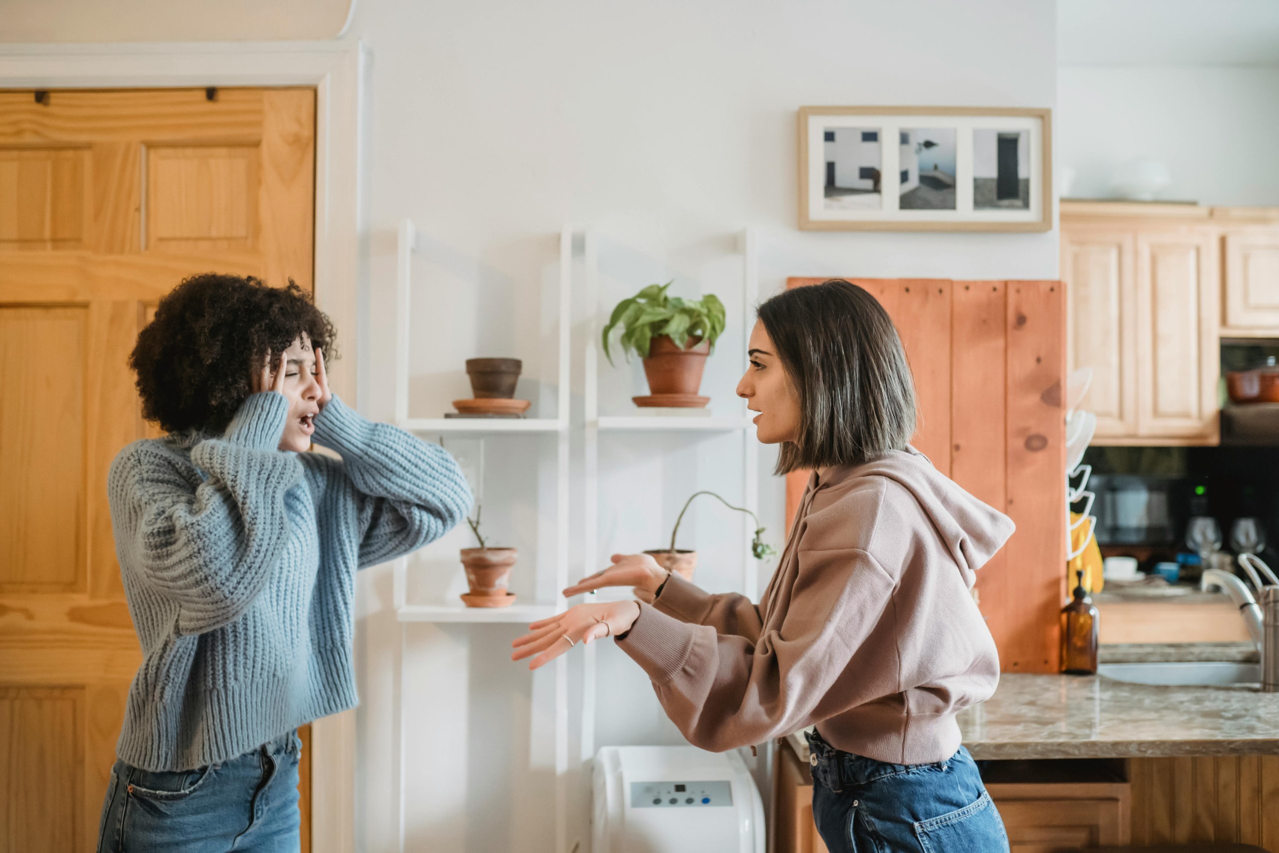 Two female friends in a home setting arguing.